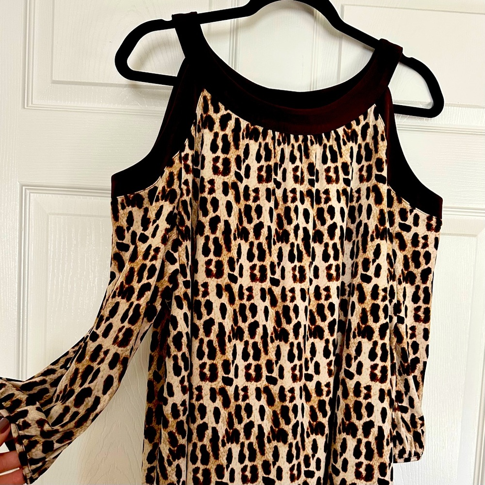Leopard print pull over cold-shoulder top with solid brown trim.